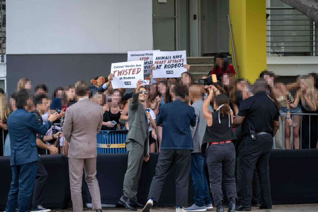 Aktive halten Schilder bei der Premiere von "Twisters"