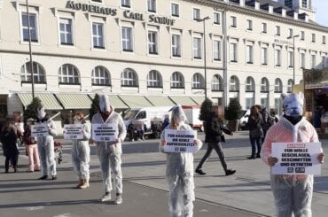 Aktive protestieren in weißen Anzügen und mit Tiermasken bekleidet in Karlsruhe