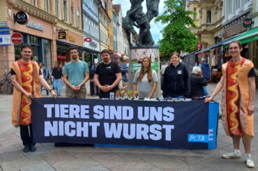 Aktive in Hot Dog Kostümen an einem PETA-Stand