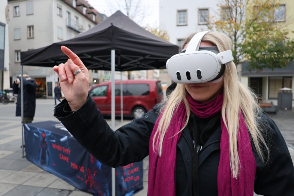Eine Frau, die die VR Brille testet und mit dem Finger zeigt.