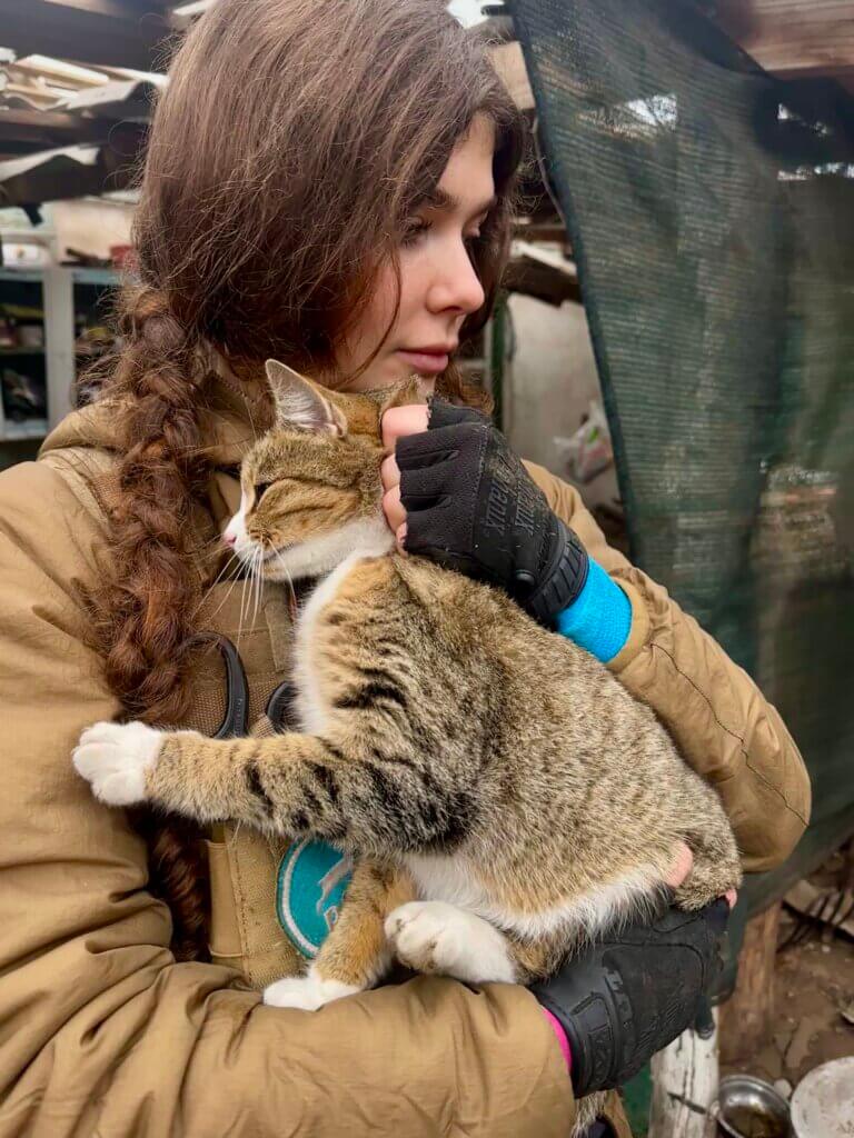 Eine Frau hält eine Katze auf dem Arm.