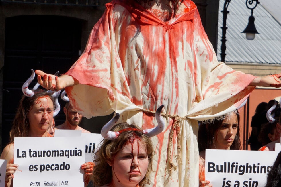 Blutverschmierter Jesus mit blutbeschmierten Stieren vor dem Rathaus in Pamplona